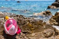 A full-face mask for snorkeling lies on the beach. Sand and water. Place for text. Pink for children and girls. Sea vacation Royalty Free Stock Photo