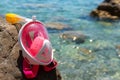 A full-face mask for snorkeling lies on the beach. Sand and water. Place for text. Pink for children and girls. Sea vacation Royalty Free Stock Photo