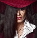 Full-face portrait of mysterious lady brunette in dark red hat with her veil down Royalty Free Stock Photo