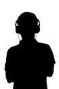 Silhouette of teenager listening to music in headphones, man folded his arms on the chest on white isolated background Royalty Free Stock Photo