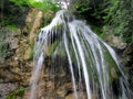 Full-flowing waterfall Dzhur-Dzhur in a mountain gorge, water flows along a rock overgrown with green moss, Crimea Royalty Free Stock Photo