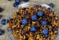 Full frame close of fresh blueberries on pile of dried fruits for fruit tea preparation on transparent glass dish. jute mat Royalty Free Stock Photo