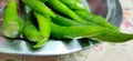 Full frame close up of a bunch of bright and shiny green chili peppers.