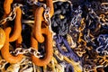 Full frame close up of old rusty brown anchor chain links on bunch of boat ropes in natural sun light Royalty Free Stock Photo