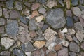 Full frame image of multicolored cobblestone with ground and green moss between stones