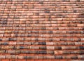 Full frame image of an old clay pantile roof with curves orange tiles in long rows