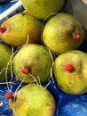 Five green pears with red dots on stems Royalty Free Stock Photo
