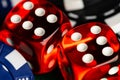 A full frame macro a pair of red translucent casino style dice showing a pair of sixes with black and blue betting chips visible Royalty Free Stock Photo