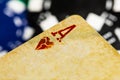 A full frame macro of a very aged, used and dirty Ace of Hearts playing card with black and blue betting chips in the background Royalty Free Stock Photo