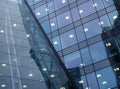 Modern office architecture abstract with geometric angular windows with lights and reflected buildings in blue glass