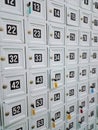 Full frame of white lockers with numbers and colorful key hang for storing visitor shoes Royalty Free Stock Photo