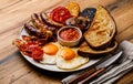 Full fry up English breakfast with fried eggs, sausages, bacon Royalty Free Stock Photo