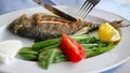 Man is eating frying fish with fork and knife in restaurant, dish closeup. Royalty Free Stock Photo