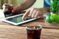 Full glass beaker of cola on a wooden table