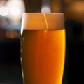 Full glass of beer on blurred lights background Royalty Free Stock Photo