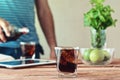 Full glass of cola in the foreground on wooden table closeup Royalty Free Stock Photo