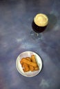 A full glass of dark beer with foam and a plate with fresh wheat croutons Royalty Free Stock Photo