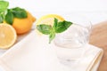 Full glass of fresh cool transparent water with lemon and mint leaves on wooden table. Close up Royalty Free Stock Photo