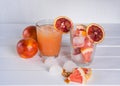 Full glass of grapefruit juice and glass of sliced fruit. Grapefruit sicilian orange with ice.