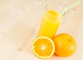 Full glass of orange juice with straw near fruit orange with space for text