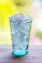 Full glass of water with ice on the wooden kitchen counter. Royalty Free Stock Photo