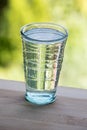 Full glass of water on the wooden kitchen counter. Green background. Royalty Free Stock Photo