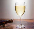 Full glass of white wine and an empty brown bottle on its side. Royalty Free Stock Photo