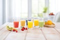 full glasses of mixed fruit juice on a white table