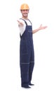 In full growth. smiling man in overalls pointing somewhere up Royalty Free Stock Photo