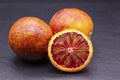 Full and two half of blood red oranges isolated on black shale background Royalty Free Stock Photo
