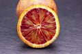 Full and two half of blood red oranges isolated on black shale background Royalty Free Stock Photo