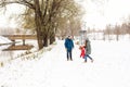 Full height of happy family with one child in winter casual oufit walking having fun outdoors