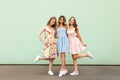 Full height image of three happy cheeky girls, best friends having fun, laughing on green background Royalty Free Stock Photo