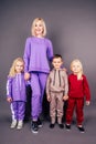 Full height mother with kids in sports suits.beautiful young blonde woman with a little boy and girls posing in sporty Royalty Free Stock Photo