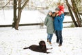 Full height portrait of happy family with one kid and dog in winter casual oufit posing outdoors Royalty Free Stock Photo