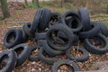 Full hull trunk Truckload of old used vintage car tyres wheels heap pile waste with some leaf