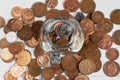 Full jar of coins from above, surrounded by loose change. Money saving and investment concept Royalty Free Stock Photo