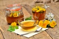 Full jar of dandelion honey, herbal tea, spring flower, fresh mint leaves, spoon and dandelion head around Royalty Free Stock Photo