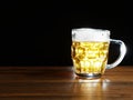 Full jar of lager beer with froth on a wooden table glowing in a dark. Alcohol consumption and sale. Copy space Royalty Free Stock Photo