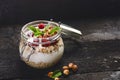 Full jar of muesli, yogurt, raspberries, nuts on a black, burnt wood table. Homemade breakfast cereals food. Healthy eating Royalty Free Stock Photo