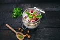 Full jar of muesli, yogurt, raspberries, nuts on a black, burnt wood table. Homemade breakfast cereals food. Healthy eating Royalty Free Stock Photo