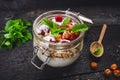 Full jar of muesli, yogurt, raspberries, nuts on a black, burnt wood table. Homemade breakfast cereals food. Healthy eating Royalty Free Stock Photo