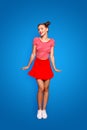 Full-legh and full-body vertical photo of charming, lovely and cute young girl isolated on red background Royalty Free Stock Photo