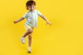 Full lengh photo of funny kid listening music in headphone and dance over yellow background. Royalty Free Stock Photo