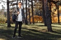 Full lengh photo of happy young male student with glasses in casual outfit holding backpack and posing at the park