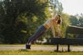 Full lenght portrait of beautiful fitness woman doing park bench push-ups. Royalty Free Stock Photo