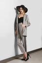 Full lenght portrait of wooman in jacket, pants with stripe and broad-brim hat Royalty Free Stock Photo