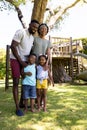 Full length of african american parents with cute children standing on grassy field in park Royalty Free Stock Photo