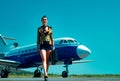 Full length of airhostess on private jet airplane on airport. Airline. Airplane and woman. Charming stewardess Royalty Free Stock Photo