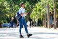 Full length attractive young african woman walking with bag and mobile phone Royalty Free Stock Photo